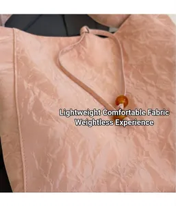 Detalle del bolso rosa con textura plisada, cordón y decoración de cuenta de ámbar