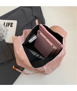 Vista superior del bolso tote rosa rugado que muestra el amplio interior negro y capacidad