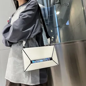 White geometric crossbody bag with clear window showing phone screen on metal background