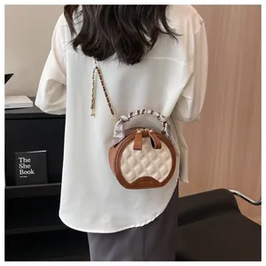 Détail d'un sac rond matelassé avec poignée en foulard et chaîne dorée