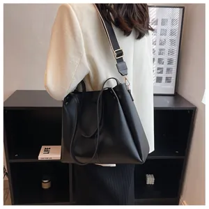 Detail of black large tote bag with textured PU leather and striped wide shoulder strap