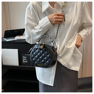 Détail du sac rond matelassé avec poignée en foulard de soie et bandoulière chaîne