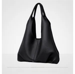 Detailed view of black litchi pattern leather tote bag with soft structure and wide strap