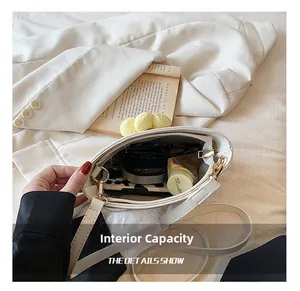 Internal capacity of white half-moon leather bag showing phone, sunglasses, and cosmetics