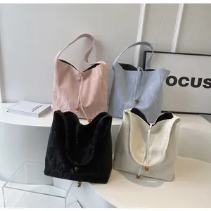 Vista detallada de bolsos en rosa, azul, negro y beige con texturas onduladas únicas