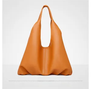 Detail of soft brown pebble leather tote bag featuring elegant vertical stitching