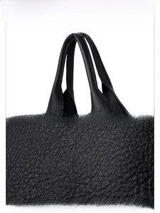 Close-up of comfortable handles and textured lychee pattern leather on the black bag