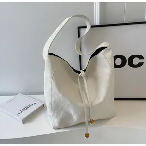Detalle de bolso tote blanco brillante con cordón ajustable y cuentas de ámbar