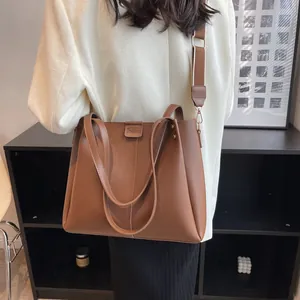 Large brown leather tote bag with wide strap for women, stylish crossbody handbag