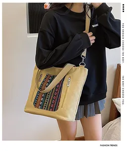 Close-up of canvas tote bag featuring colorful bohemian embroidery and metal side zippers