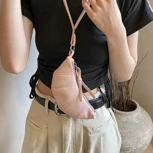 Detailed view of pink croissant-shaped mini neck bag with quilted faux leather texture
