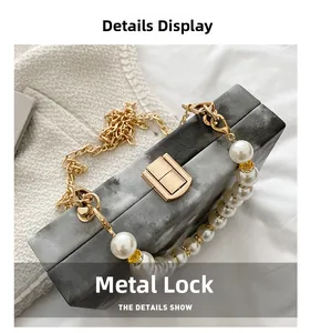 Detail of grey marble acrylic box bag with gold metal clasp and pearl handle