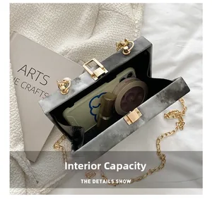 Detail showing the internal capacity of the marble pattern box bag with a gold chain