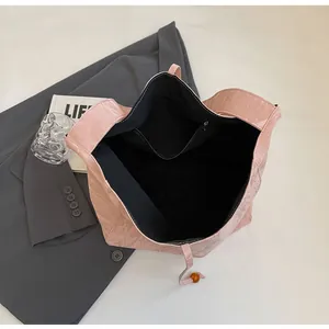 Detalle del bolso tote rosa con textura, forro interior negro y bolsillo con cremallera