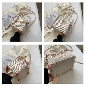 Vues détaillées du sac seau crème avec plis verticaux et chaîne en métal doré