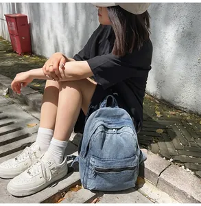 Dettaglio di uno zaino in denim blu vintage con cerniere in metallo argentato