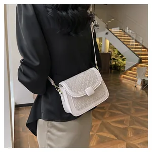 Modern white crossbody bag with woven texture worn by model in an indoor setting