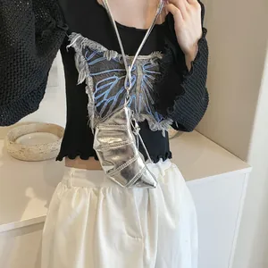 Close-up of a silver metallic croissant bag featuring pleated texture and a long crossbody strap
