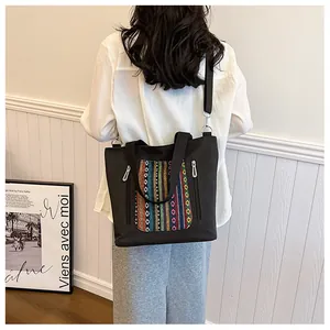 Macro detail of canvas tote bag with bohemian ethnic embroidered pocket and zippers