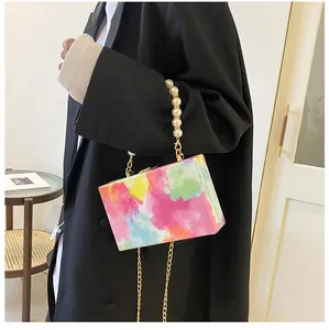 Detailed view of colorful graffiti box bag with pearl handle and gold chain strap
