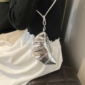 Detail of a mini silver croissant-shaped crossbody bag with metallic quilted finish