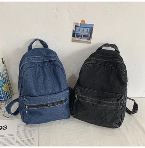 Dettaglio dei materiali degli zaini in denim lavato blu e nero con tessuto testurizzato