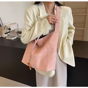 Bolso tote rosa plisado con detalle de cuentas de ámbar llevado por una modelo