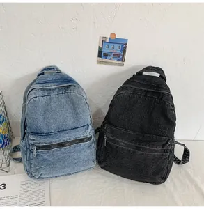 Texture dettagliata degli zaini in denim retrò in blu chiaro e nero con tasca a zip