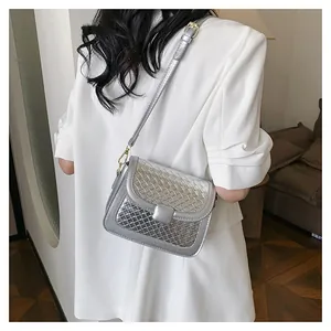Silver woven crossbody bag with metallic finish and adjustable strap worn by a model