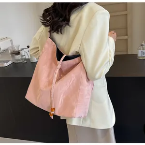 Detalle del bolso tote rosa plisado con cierre de cordón y cuentas de ámbar