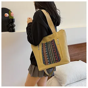 Detail of bohemian ethnic stripe embroidery on canvas tote bag with metal zipper pocket
