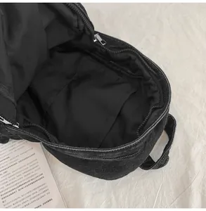 Vista interna dello zaino in denim nero con scomparto principale spazioso e fodera