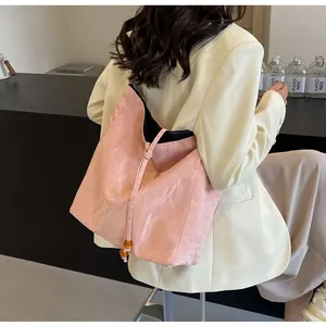 Bolso tote rosa texturizado con ajuste bandolera y detalle de cordón con una cuenta
