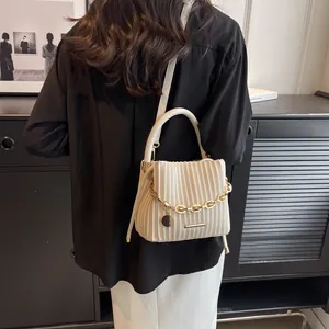 Détail du sac seau plissé beige avec chaîne dorée et bandoulière amovible