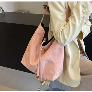 Detalle del bolso tote rosa con textura de mármol, cuentas de ámbar y cordón en la tela