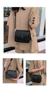 Detail of black woven crossbody bag with square buckle and adjustable strap