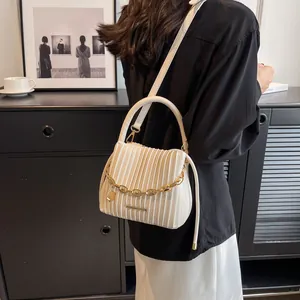 Détail du sac seau plissé blanc avec chaîne dorée et bandoulière amovible
