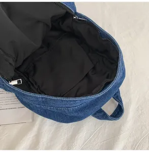 Dettaglio interno dello zaino in denim vintage con fodera nera e tasca aperta