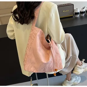 Bolso tote rosa con textura metalizada y cuentas de ámbar, lucido con traje elegante