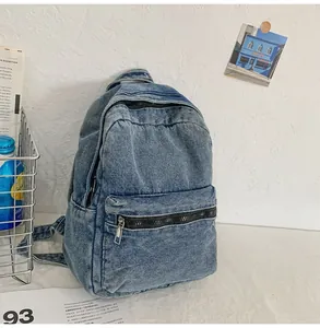 Dettaglio del tessuto denim blu lavato di uno zaino con tasca frontale con cerniera