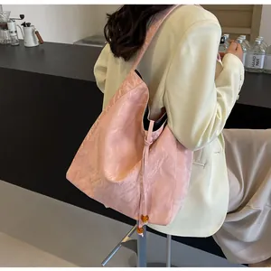 Detalle del bolso tote plisado rosa con cordón, cuentas de ámbar y textura suave