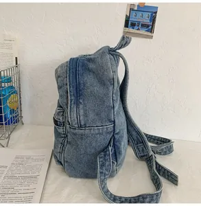 Dettaglio dello zaino in denim lavato con tasca laterale a zip e spallacci regolabili