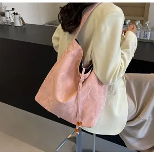 Detalle del bolso tote rosa con textura arrugada y cordón con elegante cuenta de ámbar