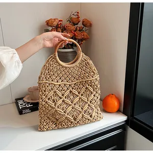 Detalle del bolso de playa de macramé con diseño de malla hueca y asa redonda