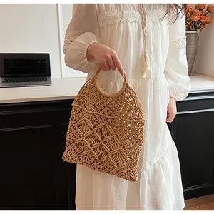 Detalle del bolso de macramé tejido a mano con asas redondas de madera y diseño rombos