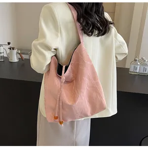 Vista detallada del bolso tote rosa con textura arrugada y detalle de perla ámbar
