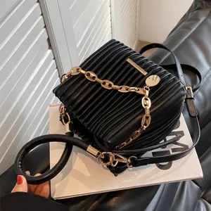 Sac seau plissé noir chic avec chaîne dorée et double bandoulière sur présentoir