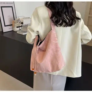 Detalle de bolso tote rosa con textura plisada y cordón con cuentas de ámbar