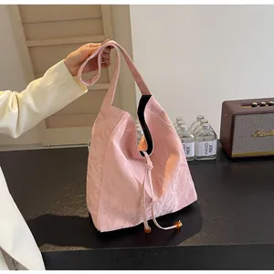 Detalle de textura de bolso tote plisado rosa con cordón y cuentas decorativas