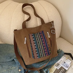 Brown canvas tote bag with colorful ethnic embroidery and adjustable shoulder strap